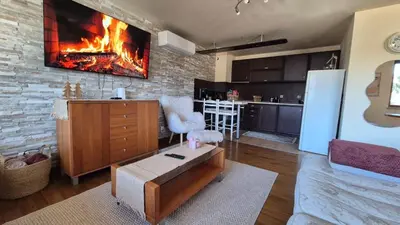 a kitchen with a living room with a fireplace at 3 bedroom Penthouse only 700 meters from Ski Lift in Bansko