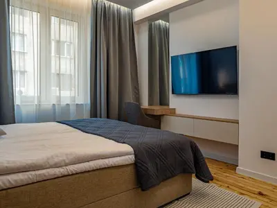 a bedroom with a bed and a flat screen tv at Stylish New High-End 3BR Apt on Vitoshka Blvd in Sofia