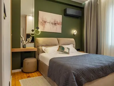 a bedroom with a bed and a green wall at Stylish New High-End 3BR Apt on Vitoshka Blvd in Sofia