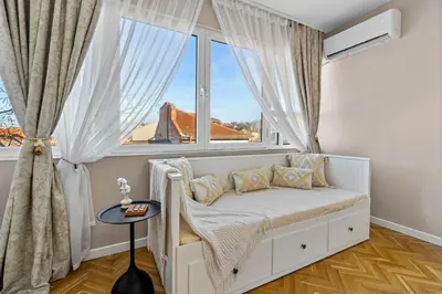 a bed in a room with a large window at Kapana - a 106m2 Flat right on the Pedestrian Street in Plovdiv