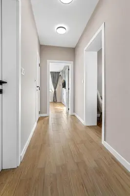 an empty hallway with white walls and wood floors at Kapana - a 106m2 Flat right on the Pedestrian Street in Plovdiv