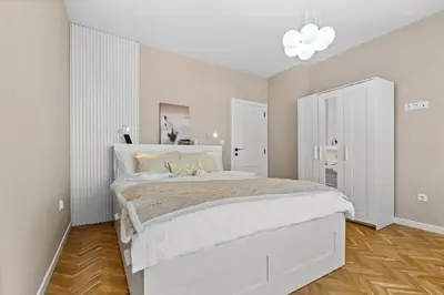 a white bedroom with a large white bed in it at Kapana - a 106m2 Flat right on the Pedestrian Street in Plovdiv