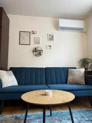a blue couch in a living room with a coffee table at Panorama Studio Home2Host in Bansko