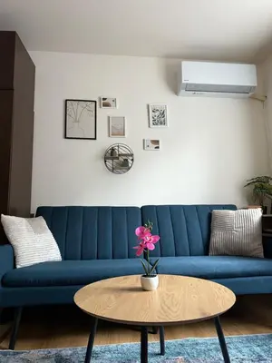 a blue couch in a living room with a table at Panorama Studio Home2Host in Bansko