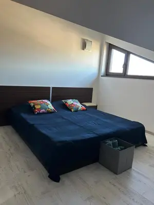 a bedroom with a bed with blue sheets and a window at Golf view in Razlog