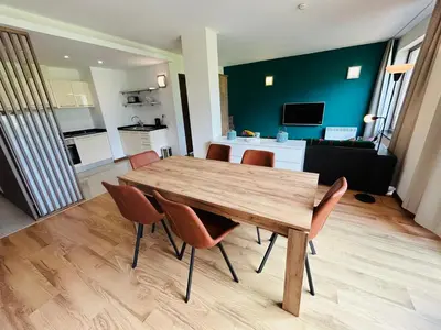 a dining room with a wooden table and chairs at Golf view in Razlog