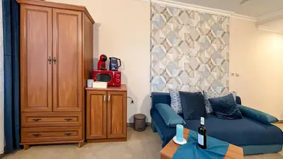 a living room with a blue couch and a cabinet at Bansko Peak Apartments 106 in Bansko