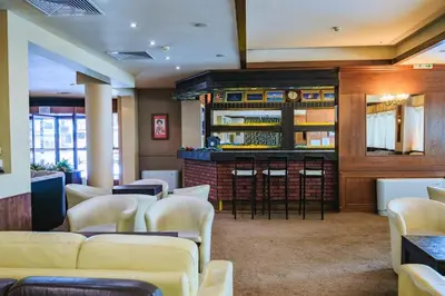 a waiting room with white chairs and a bar at Bansko Peak Apartments 106 in Bansko