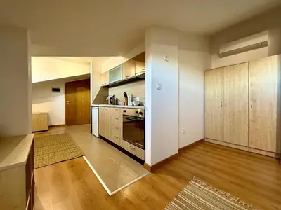 a large kitchen with wooden cabinets and a stove at Green Elephant in Razlog