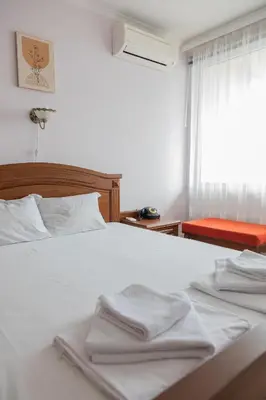 a bedroom with a white bed with towels on it at Апартамент в центъра на Хисаря in Hisarya
