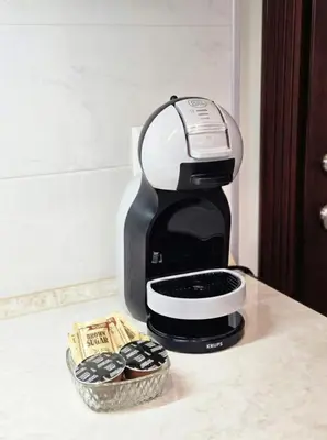 a coffee maker on a counter next to a bowl of cookies at Апартамент в центъра на Хисаря in Hisarya