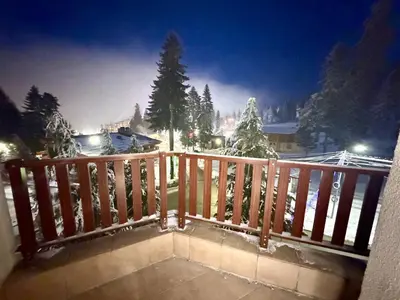 a balcony with a view of a snow covered yard at Flora Residence Cozy Apartments in Borovets