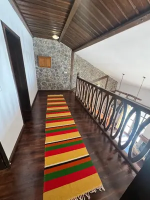 a staircase with a colorful rug on the floor at Къща за гости Пампорово в махала Кочорите in Pamporovo