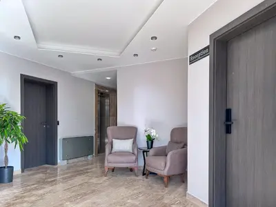 a hallway with two chairs and a table with flowers at Vital Hotel in Sofia