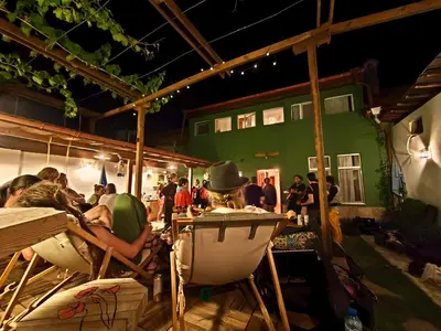 a group of people sitting in chairs under a building at PORTALA Urban Lodge in Rila