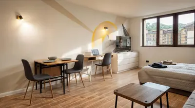 a room with a bed and a table and chairs at Парксайд Лейн Студио in Bansko