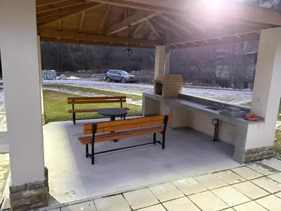 two benches sitting under a pavilion with a grill at Парксайд Лейн Студио in Bansko