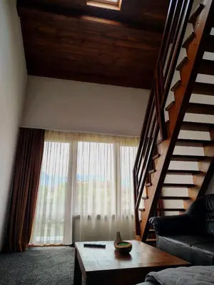 a living room with a staircase and a couch and a table at къща за гости Цветелина и Митко in Bansko