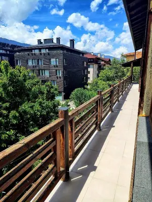 a wooden fence on a walkway in a city at къща за гости Цветелина и Митко in Bansko