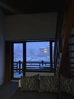 a living room with a large window and a couch at къща за гости Цветелина и Митко in Bansko