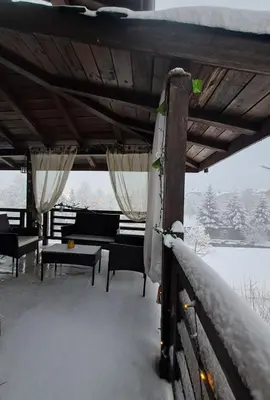 a porch covered in snow with a table and chairs at къща за гости Цветелина и Митко in Bansko