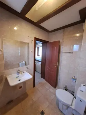 a bathroom with a white toilet and a sink at къща за гости Цветелина и Митко in Bansko