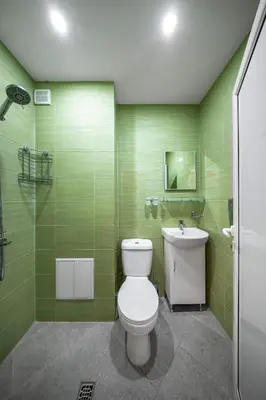 a green bathroom with a toilet and a sink at Life in Colours - Artistic 1BD Apartment in Sofia