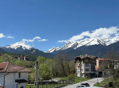 a view of snow capped mountains from a city at Yeti Complex in Bansko