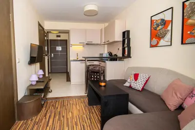 a living room with a couch and a kitchen at Private Ap in Perun Lodge Ski Escape & Spa in Bansko