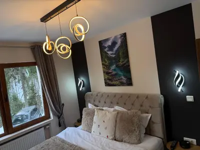 a bedroom with a bed with white sheets and lights at Elizi2 winter apartments Pamporovo in Pamporovo