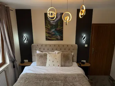 a bedroom with a bed with lights above it at Elizi2 winter apartments Pamporovo in Pamporovo