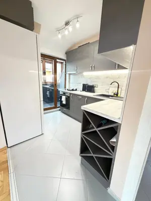 a kitchen with gray cabinets and a white tile floor at New cozy apartment with undefloor heating 86m2 in Sofia