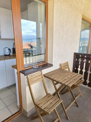a wooden table and chairs in a kitchen with a window at Balcony and Mountain View 7 min Walk to Ski Gondola in Bansko