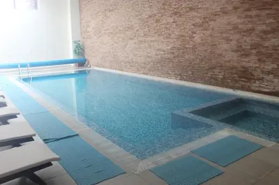 a swimming pool in a room with a brick wall at Comfort apartment in the house in Razlog