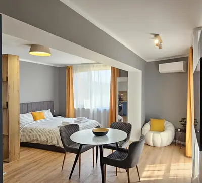 a bedroom with a bed and a table and chairs at By The Pool Apartments #10 in Velingrad