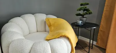 a white chair with a yellow blanket on a table at By The Pool Apartments #10 in Velingrad