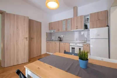 a kitchen with a table and a white refrigerator at Beautiful Bright and Spacious Central Apt in Sofia
