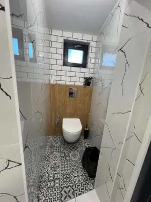 a bathroom with a toilet and a tile floor at Plovdiv City Apartments in Plovdiv