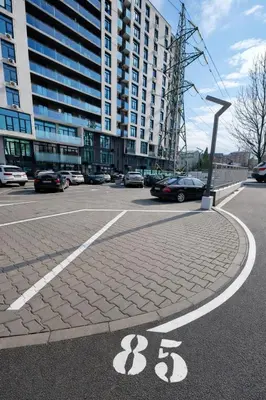 a parking lot with cars parked in front of a large building at Mountain View Escape - Cozy Apt with Private Parking in Sofia
