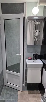 a bathroom with a sink and a shower backdoor at ZAKKY STUDIO Cozy Apartment to the City Center and International Fair in Plovdiv