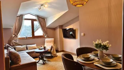 a living room with a table and a couch at Cozy Stylish 2-bedroom apt near ski road, 5min to Gondola & bars in Bansko
