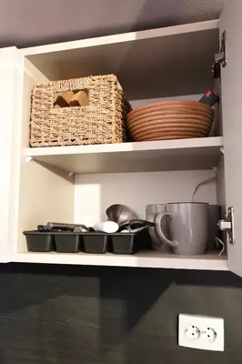 a kitchen shelf with bowls and utensils and a basket at Cozy Stylish 2-bedroom apt near ski road, 5min to Gondola & bars in Bansko