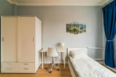 a bedroom with a bed and a cabinet and a desk at Central Apartment near NDK in Sofia