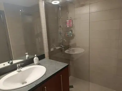 a bathroom with a sink and a glass shower at Lyra Forest Apartment in Borovets