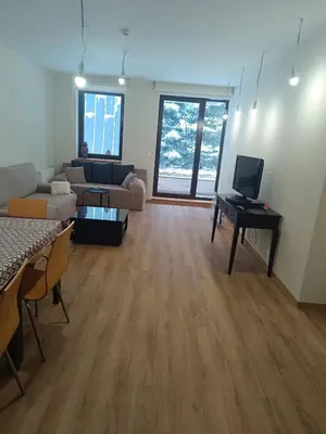 a large living room with a couch and a tv at Lyra Forest Apartment in Borovets
