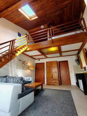 a living room with a white couch and a loft at Цветелина и Митко in Bansko