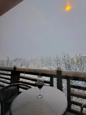a glass of wine sitting on a table on a balcony at Цветелина и Митко in Bansko