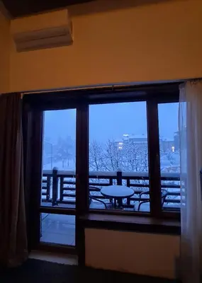 a room with a window with a table and a view at Цветелина и Митко in Bansko