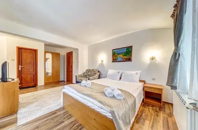 a bedroom with a large bed and a couch at Комплекс Райковски Ливади in Pamporovo