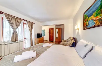 a bedroom with two beds and a painting on the wall at Комплекс Райковски Ливади in Pamporovo